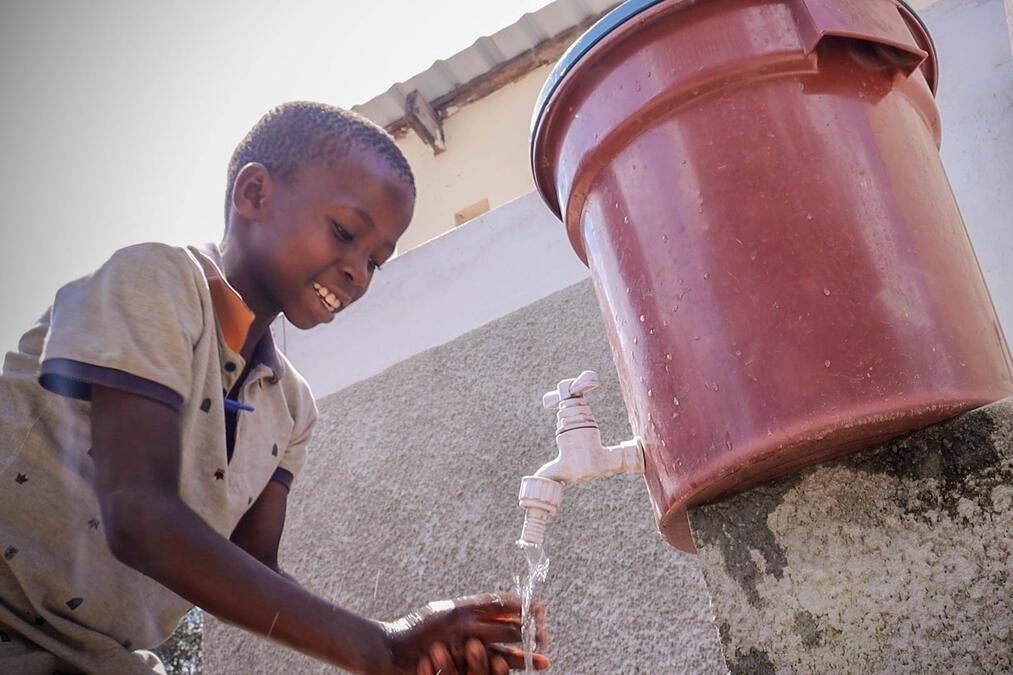 Jongen in Mozambique wast zijn handen bij een kraantje met schoon water