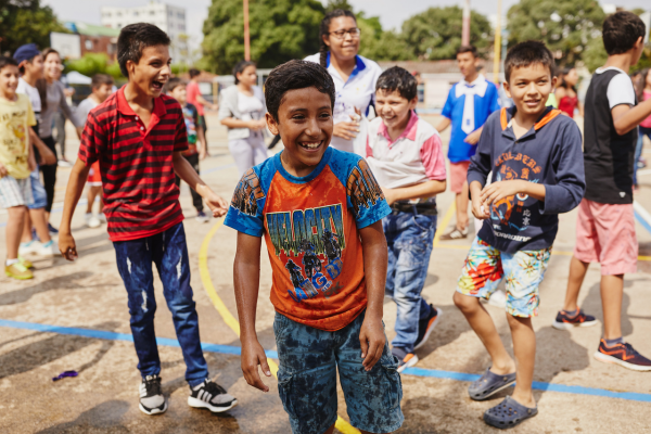 Vrolijke kinderen hebben waterpret op het schoolplein 