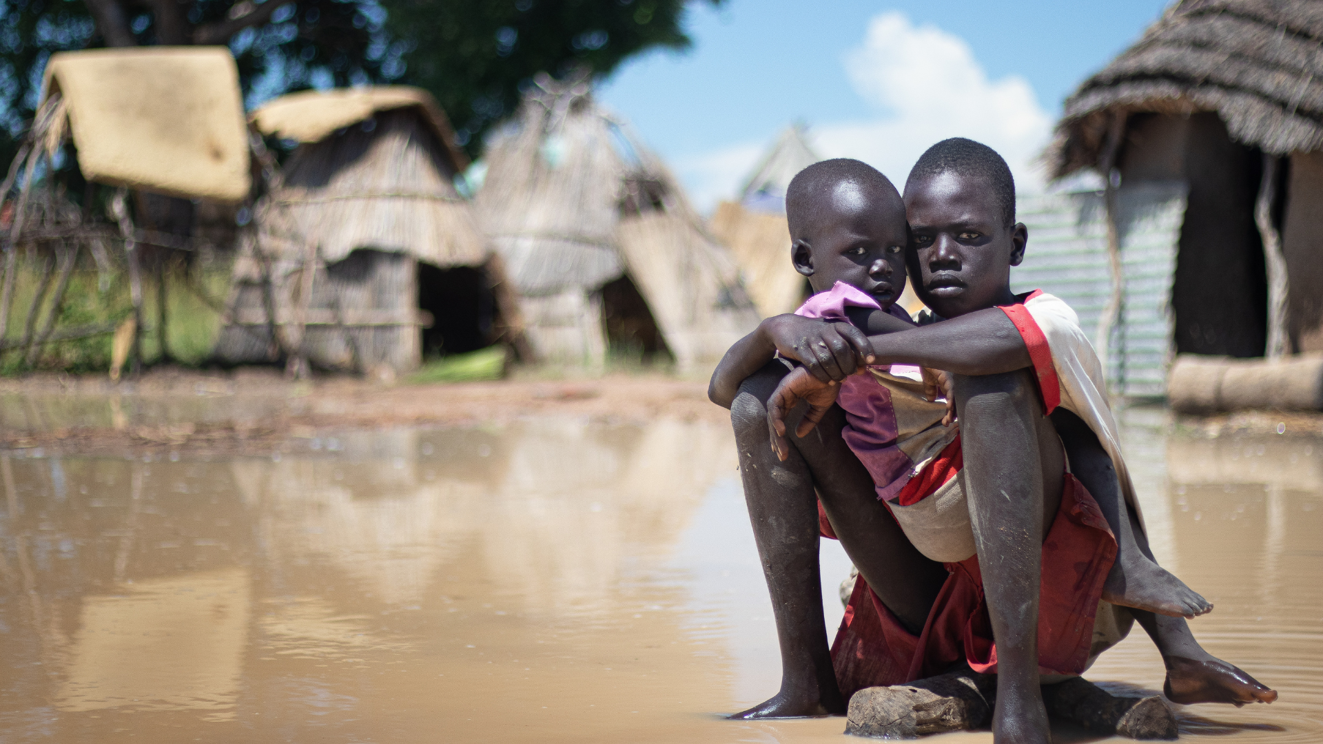 Afrikaanse kinderen zitten bij elkaar in overstroomd gebied.