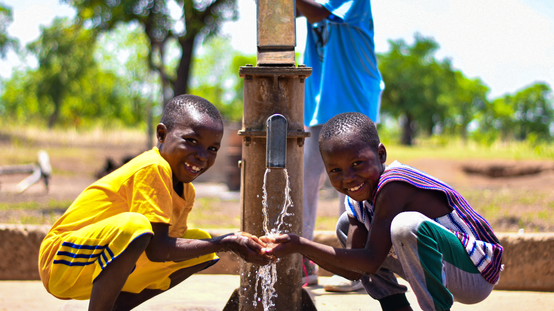 Drie kinderen halen water in Afrika bij de waterput