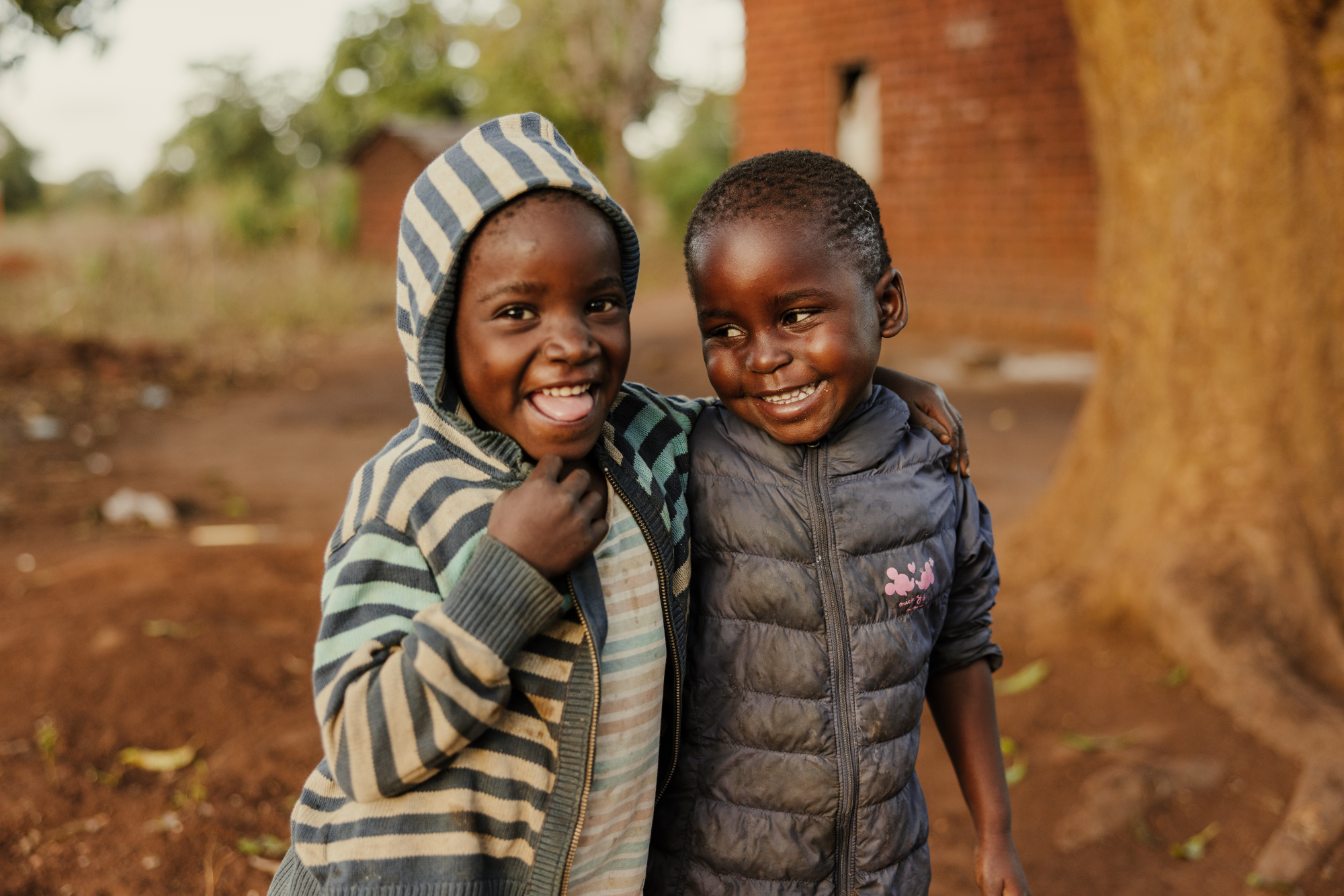 Twee vriendjes uit Malawi lachen naar elkaar
