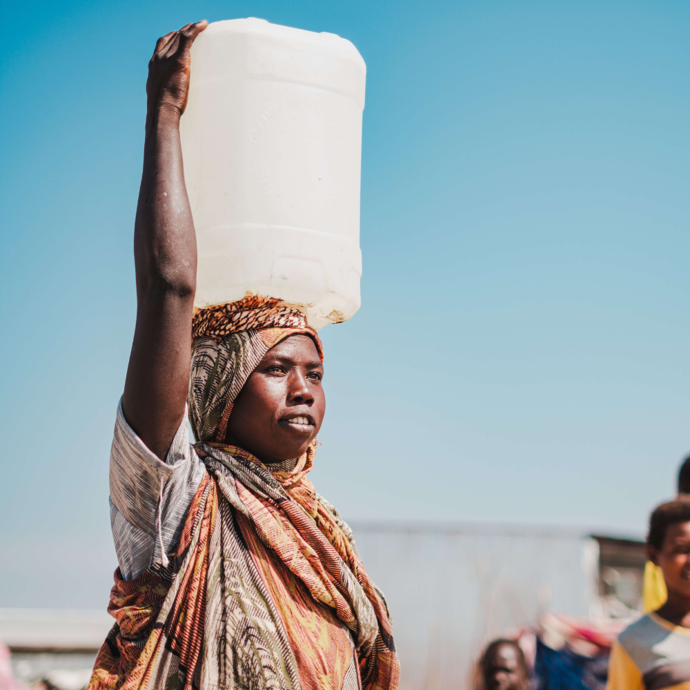Vrouw in Zuid-Soedan met jerrycan water op haar hoofd