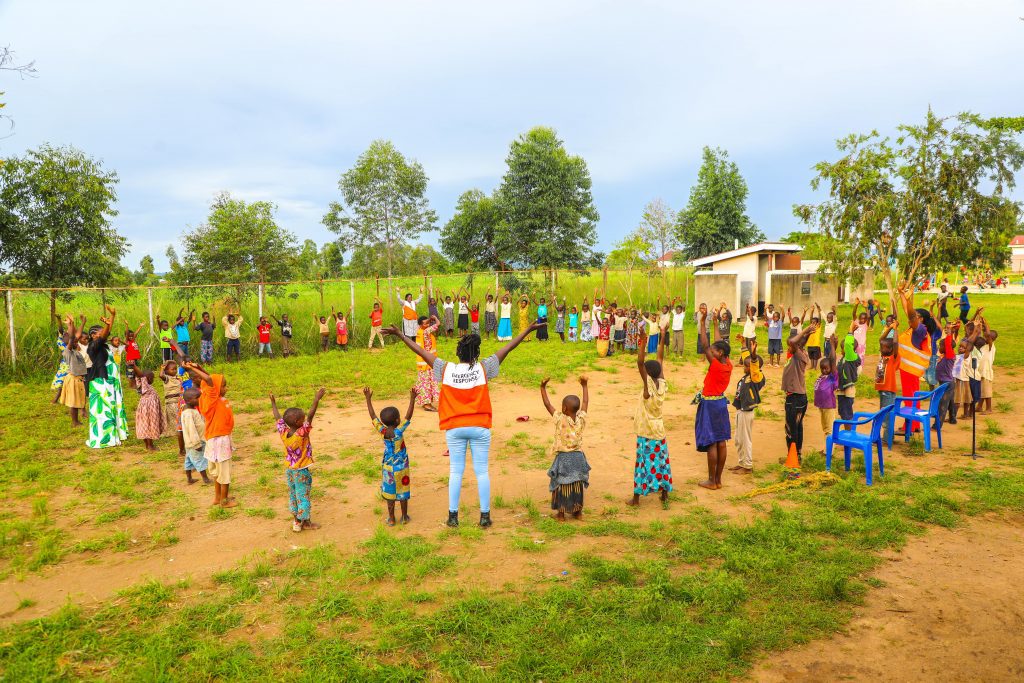 World Vision employees and children in a circle playing games