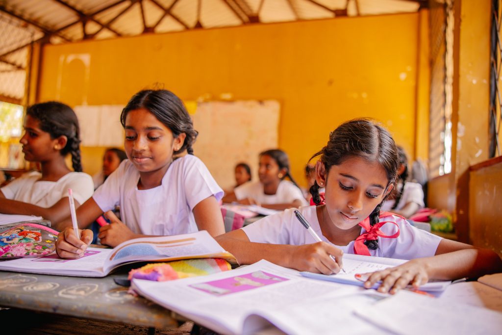 Meisjes in Sri Lanka die aan schoolwerken in een klaslokaal