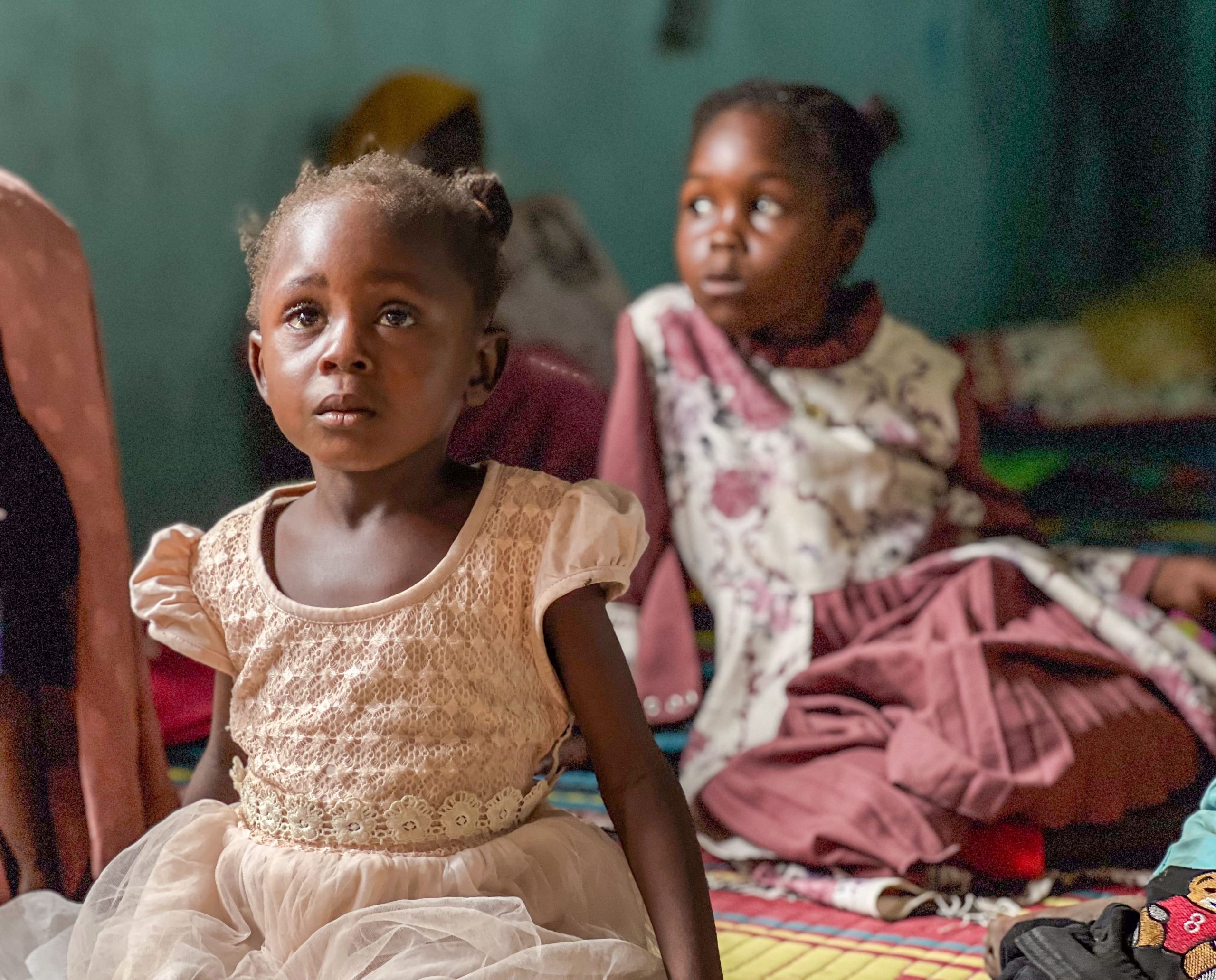Twee kleine meisjes zittend op de grond luisterend