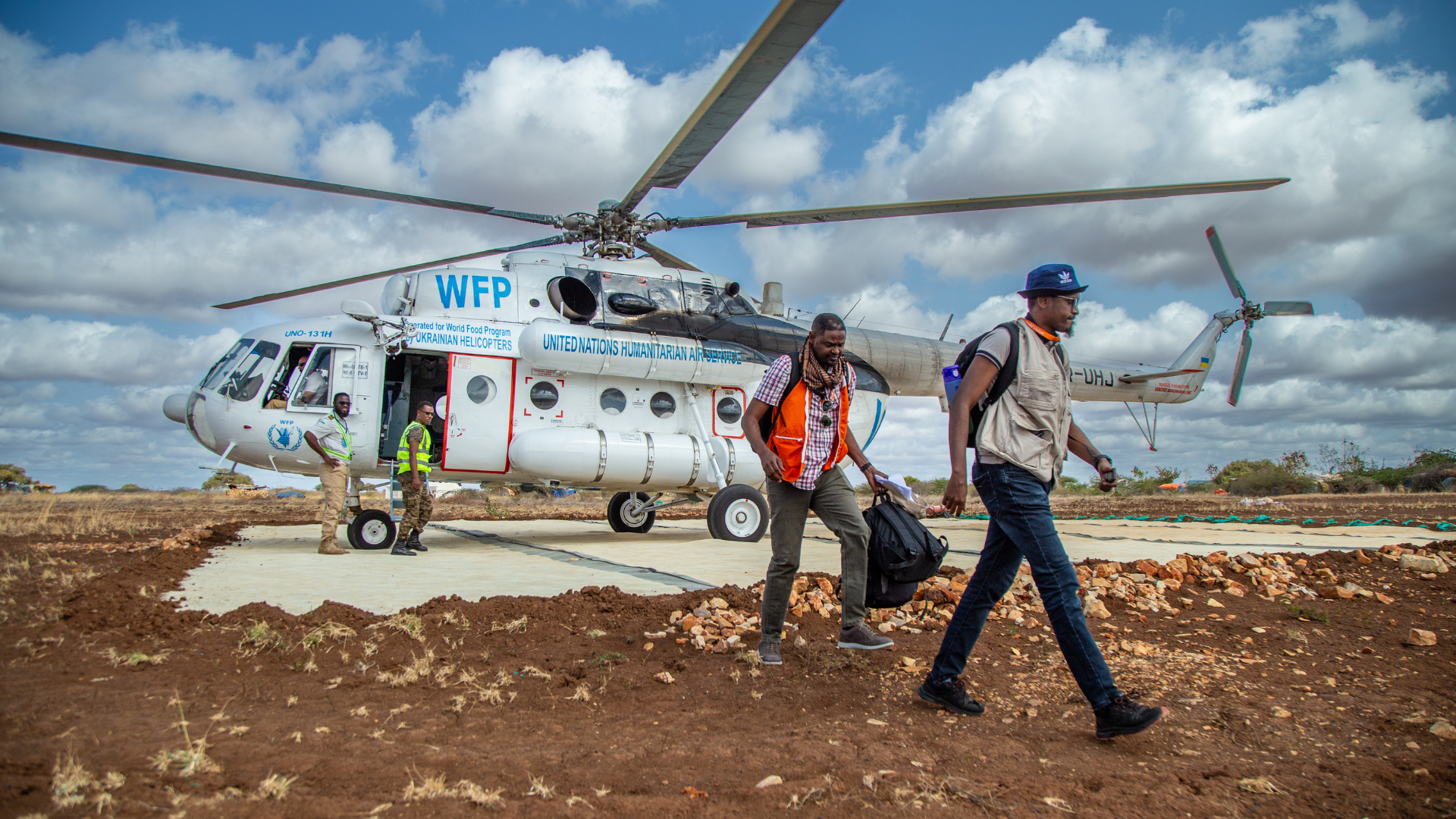 Hulpverleners World Vision bij een helikopter