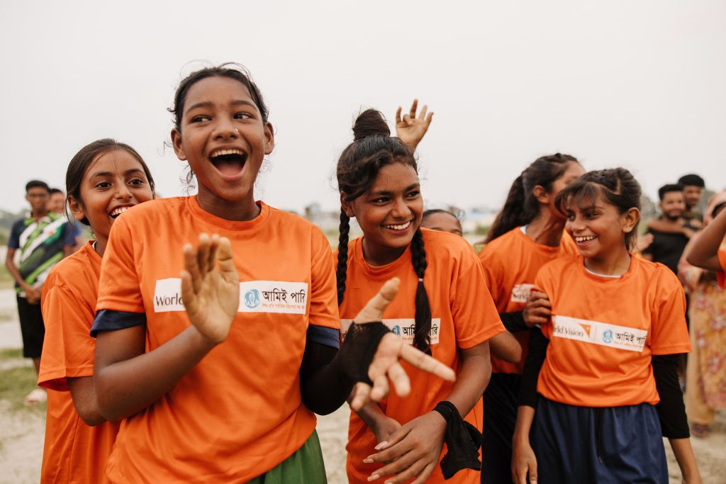 Juichende meisjes in oranje World Vision shirts